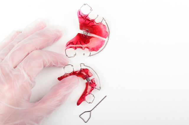 床矯正の装置を持った手とネジを締めるドライバーのイメージ