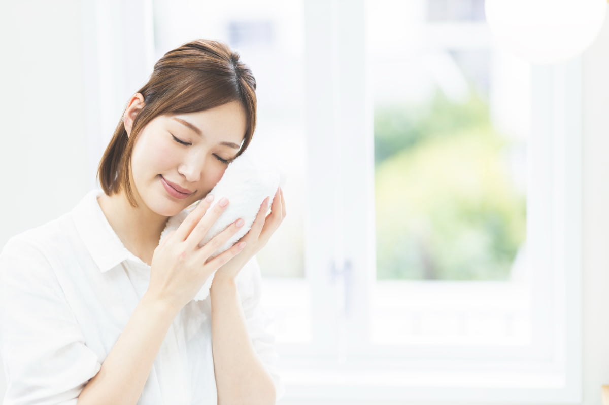 親知らずが痛みタオルで冷やす女性