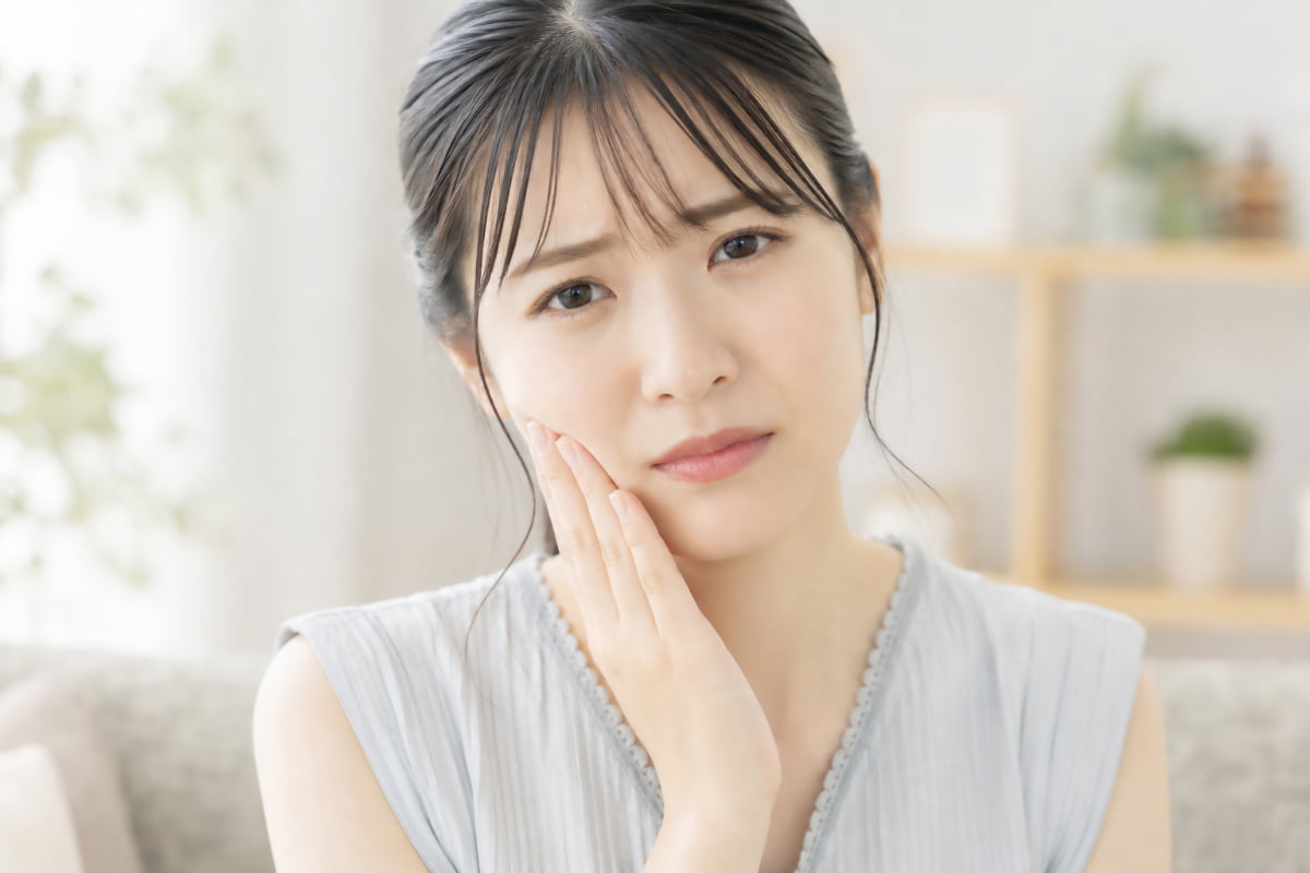親知らずが痛いのはなぜか考える女性