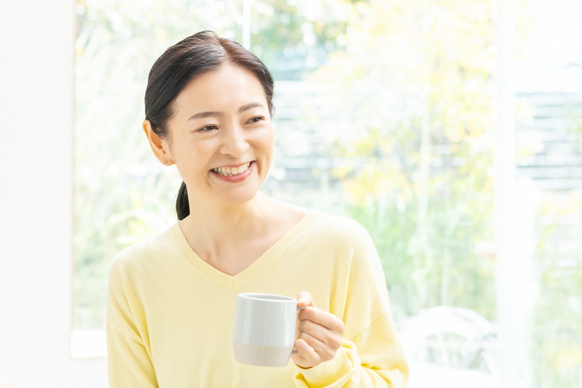 飲み物を片手に微笑む女性